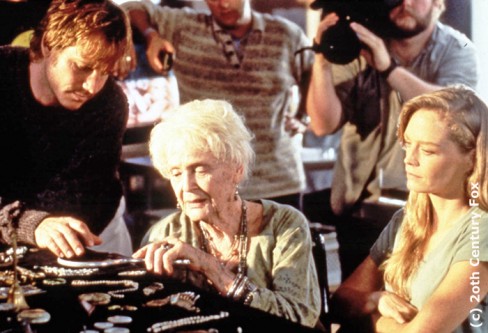 Still of Gloria Stuart with Bill Paxton and Suzy Amis on the set of Titanic, with a cameraman in the background