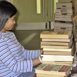 A volunteer sitting at a table, cataloguing books