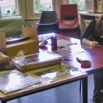 A volunteer writing at a table