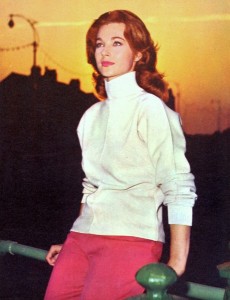 Shirley Anne Field in polo-neck jumper against cityscape sunset