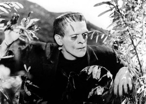 Boris Karloff as Frankenstein's Monster coming through undergrowth