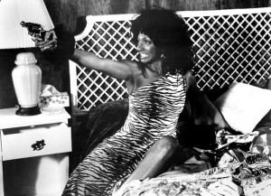 Nichelle Nichols in animal print pointing gun