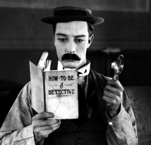 Buster Keaton with book and magnifying glass
