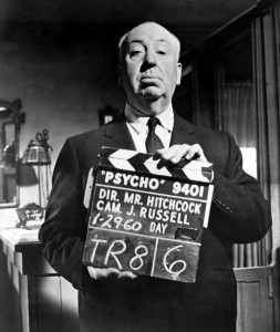 Alfred Hitchcock holding a clapperboard labelled 'Psycho'